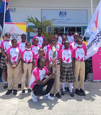 Students from the Lookout Primary School, Montserrat pose with athlete Jehmari Lee at the Queen's Baton Relay celebration