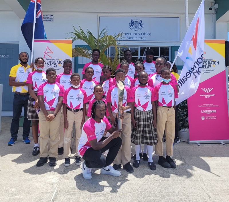 Students from the Lookout Primary School, Montserrat pose with athlete Jehmari Lee at the Queen's Baton Relay celebration
