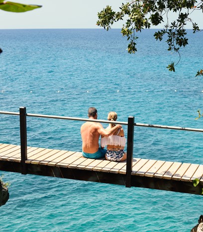 Tourist sitting above water on a bridge in Jamaica 