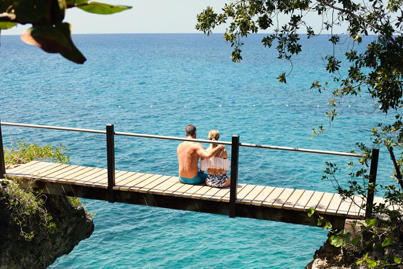 Tourist sitting above water on a bridge in Jamaica 