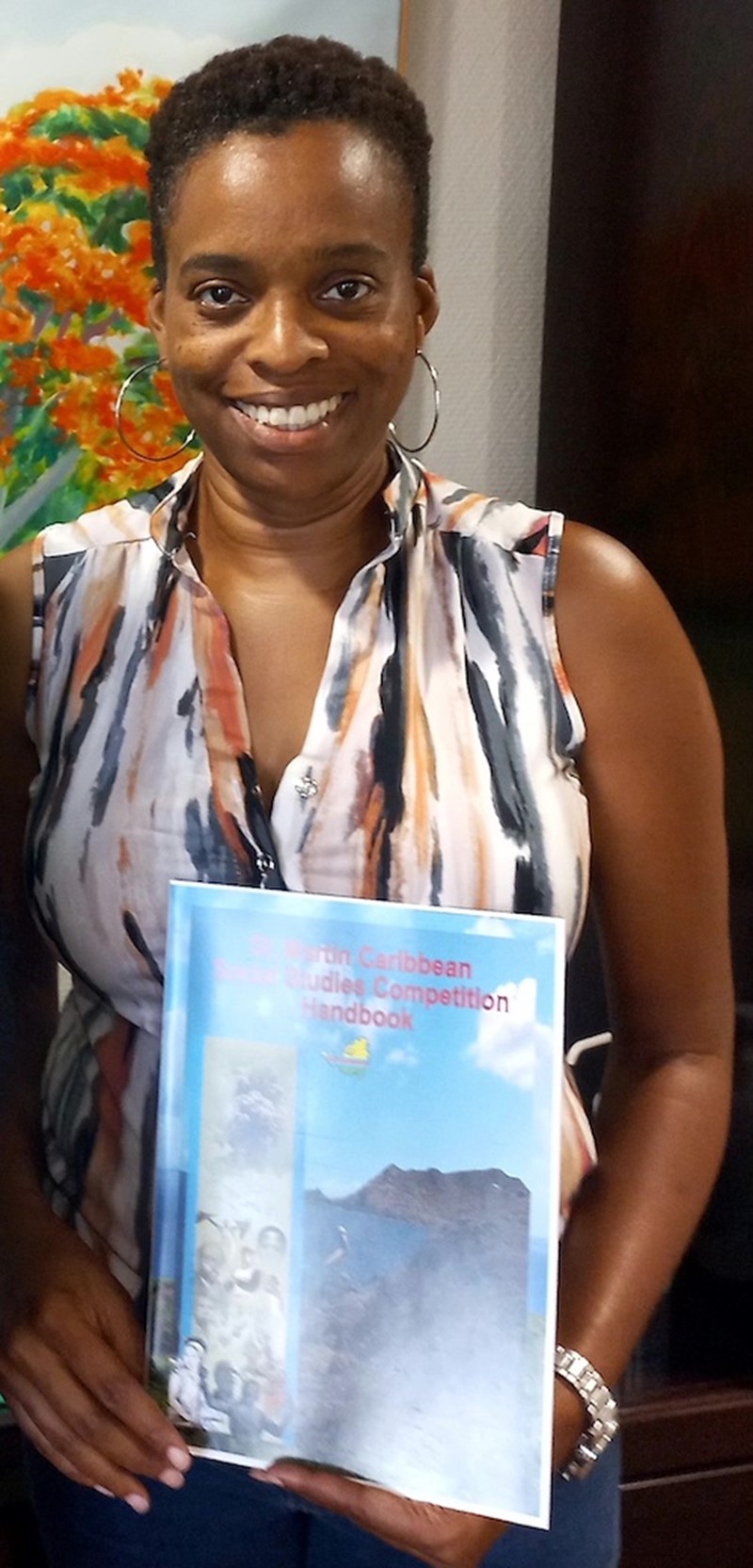 Merlyn Joseph, teacher, and St. Martin Book Fair Committee member holds the “St. Martin Caribbean Social Studies Competition” booklet, used by students, ages 14 to 17, to prepare for the Caribbean knowledge quiz