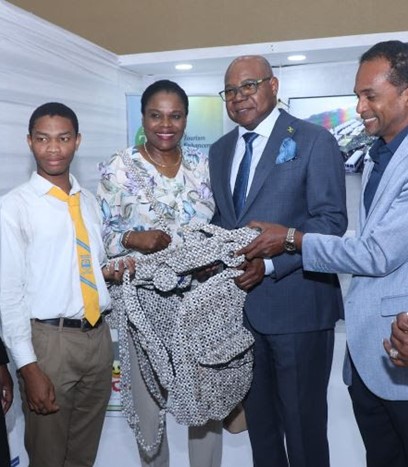 Tourism Minister, Hon. Edmund Bartlett (third from left) admires the hand-sewn beaded bag and model-car made by Seaforth High student Juantae Wong (second left). Sharing in the moment are, (from left) Director of the Tourism Linkages Network of the TEF, Carolyn McDonald Riley, Permanent Secretary of the Ministry of Tourism, Jennifer Griffith, Executive Director of the Tourism Enhancement Fund, Dr. Carey Wallace and Director of the Jamaica Centre of Tourism Innovation, Carol Rose Brown. 