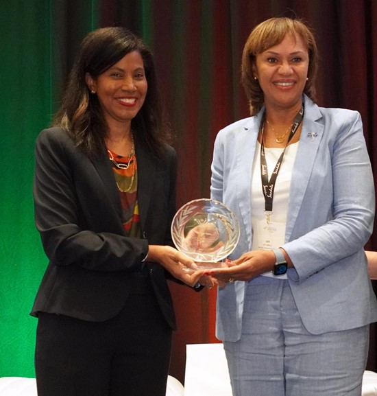 Joy Jibrilu, CEO of the Nassau Paradise Island Promotion Board (right), accepts the late George Myers’ Icon of Caribbean Hospitality award from CHTA President Nicola Madden-Greig.