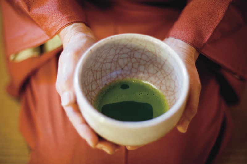 Japanese Green Tea being held in a woman's hand
