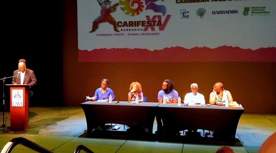 The master of ceremonies at the podium introduced the Carifesta XV Symposia panel, R–L: Bernice L. McFadden, U.S. novelist and professor; Lasana M. Sekou, St. Martin author and publisher; Marlon James, U.S.- based Jamaican novelist; Nancy Morejón, internationally acclaimed Cuban poet; and moderator Lafleur Cockburn of St. Vincent & the Grenadines. (Photo courtesy Sandra Sealy)